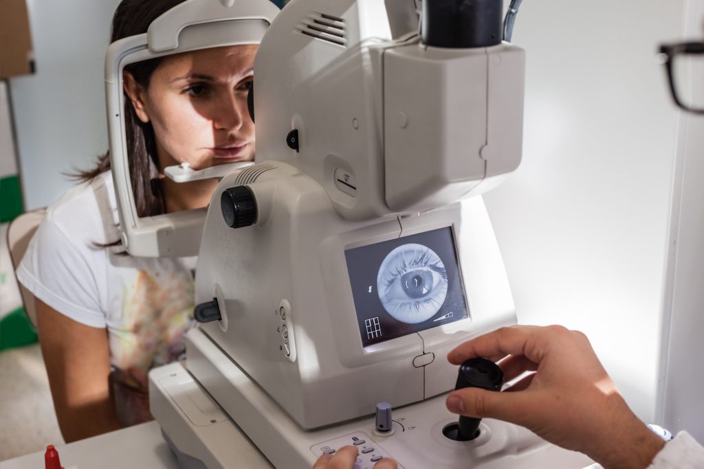 a young ophthalmologist using a non-mydriatic retinal camera on a young girl